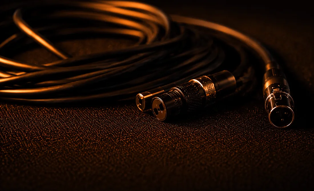 Coiled XLR cables and connectors lit in warm orange